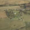 Oblique aerial view centred on the country house, greenhouse, walled garden, cottage, stables and sawmill, taken from the SE.