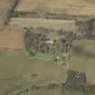 Oblique aerial view centred on the country house, greenhouse, walled garden, cottage, stables and sawmill, taken from the SE.