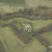 Oblique aerial view centred on the country house with stables, gate-lodge, gate piers and gates adjacent, taken from the S.