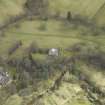 Oblique aerial view centred on the country house and stables and the remains of the church, taken from the W.