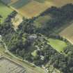 Oblique aerial view centred on the country house, cottage and church, taken from the ESE.