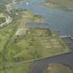 General oblique aerial view of the remains of the shipyard with the castle in the distance, taken from the WNW.