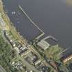 Oblique aerial view of the remains of the shipyard centred on the buildings and piers, taken from the NW.