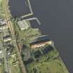 Oblique aerial view of the remains of the shipyard centred on the buildings and piers, taken from the WNW.