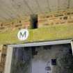 Detail. Entrance to processing room showing concrete lintel and painted  'M' letter room identification.