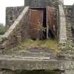 Detail.  Entrance to exposed concrete and brick magazine showing metal doors and tramway sleepers still in situ from SW.