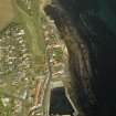 Oblique aerial view of the village centred on the harbour with the cottages and dairy adjacent, taken from the SW.