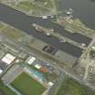 Oblique aerial view centred on the burnt out sugar warehouse and the docks, taken from the S.