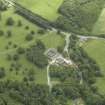 Oblique aerial view centred on the stable block, gate-lodge and road bridge, taken from the NNW.