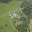 Oblique aerial view centred on the farmsteading and gate-lodge, taken from the SE.