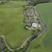 Oblique aerial view of the village centred on the woollen mill, taken from the NW.