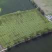 Oblique aerial view centred on the cropmarks of the rig with the farmhouse and farmsteading adjacent, taken from the ENE.