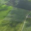 Oblique aerial view centred on the cropmarks of the unenclosed settlement, enclosures, roundhouse and possible square barrow with the cropmarks of the possible pit alignment, rig and scatter of pits adjacent, taken from the ENE.