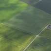 Oblique aerial view centred on the cropmarks of the unenclosed settlement, enclosures, roundhouse and possible square barrow with the cropmarks of the possible pit alignment, rig and scatter of pits adjacent, taken from the NE.