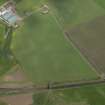 Oblique aerial view centred on the cropmarks of the unenclosed settlement, rig and pits, taken from the WNW.