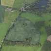 Oblique aerial view centred on the cropmarks of the pits and rig with the farmhouse and farmsteading adjacent, taken from the SW.