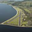 General oblique aerial view centred on the airfield during resurfacing of the runway, taken from the S.