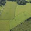 Oblique aerial view centred on the remains of the standing stones, henge and barrow, taken from the NW.