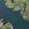 General oblique aerial view centred on the church, pier and cottages, taken from the S.