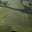 Oblique aerial view centred on the cropmarks of the rig and pits with the farmhouse and farmsteading adjacent, taken from the SE.