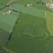 Oblique aerial view centred on the cropmarks of the ring-ditches and rig with the farmhouse and farmsteading adjacent, taken from the NE.