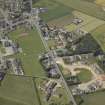 Oblique aerial view of the village centred on the school and church, taken from the SE.