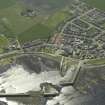 General oblique aerial view of the village centred on the harbour, taken from the NE.