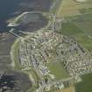 General oblique aerial view of the village centred on the harbour, taken from the NW.