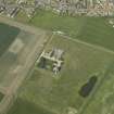 Oblique aerial view centred on the farmhouse and farmsteading, taken from the SE.