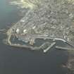 Oblique aerial view centred on the harbour, harbour basin, beacon, pier and jetties, taken from the WNW.