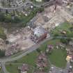 Oblique aerial view centred on the whisky distillery during demolition, taken from the SSW.