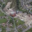 Oblique aerial view centred on the whisky distillery during demolition, taken from the ESE.