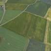 Oblique aerial view centred on the cropmarks of the pits, rig and unenclosed settlement with the cropmarks of the ring-ditches and railway adjacent, taken from the NE.