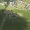 General oblique aerial view centred on the remains of the abbey and burial-ground and the farmsteading, taken from the SE.