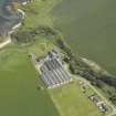 Oblique aerial view centred on the whisky distillery with the remains of the windmill adjacent, taken from the SW.