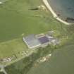 Oblique aerial view centred on the whisky distillery with the remains of the windmill adjacent, taken from the ESE.