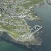 Oblique aerial view of the village centred on the harbours, taken from the NE.