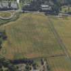Oblique aerial view centred on the cropmarks of the settlement and fort with the church adjacent, taken from the N.