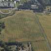 Oblique aerial view centred on the cropmarks of the settlement and fort with the church adjacent, taken from the N.