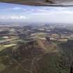 General oblique aerial view centred on the remains of the fort with the village in the distance, taken from the SW.