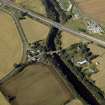 Oblique aerial view centred on the road bridges and tollhouse with the church and burial ground adjacent, taken from the E.