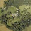 Oblique aerial view centred on the country house and gardens with the cottage adjacent, taken from the S.