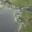 Oblique aerial view of the village centred on the whisky distillery and pier, taken from the NE.