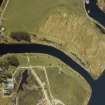 Oblique aerial view centred on the Mucomir Cut, the electricity generating station, bridge, road bridge, beacon, farmhouse and farmsteading, taken from the NE.