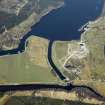 General oblique aerial view centred on the Mucomir Cut, the electricity generating station, bridge, road bridge, beacon, farmhouse and farmsteading, taken from the SSW.