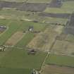 Oblique aerial view of the village centred on the pattern of dispersed buildings and layout of regular fields, taken from the NW.