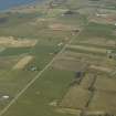 General oblique aerial view of the village centred on the pattern of dispersed buildings and layout of regular fields, taken from the SSW.
