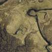 Oblique aerial view centred on the remains of the farmstead, taken from the SW.