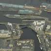 Oblique aerial view centred on the swing bridge, road bridge and office with the harbour, dock and dry dock adjacent, taken from the SW.