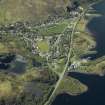 Oblique aerial view of the village centred on the harbour, slate quarries and remains of the fort, taken from the NE.